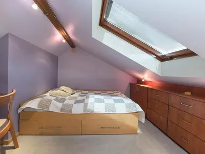 a attic bedroom with a bed and a skylight at OLSZA RESIDENCE Cozy & quiet 2 level apartment in Kraków
