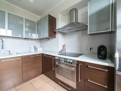 a kitchen with wooden cabinets and a stove top oven at OLSZA RESIDENCE Cozy & quiet 2 level apartment in Kraków