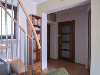 a living room with a staircase and a book shelf at OLSZA RESIDENCE Cozy & quiet 2 level apartment in Kraków