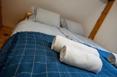 a blue bed with two towels on it at Chata Pod Lasem in Poręba