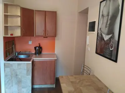 a small kitchen with a sink and a table at Akt Studio Apartment City Centre in Kraków