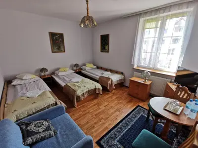 a living room with two beds and a couch at Hotel TERESITA in Kraków