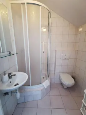 a bathroom with a shower and a sink and a toilet at Hotel TERESITA in Kraków