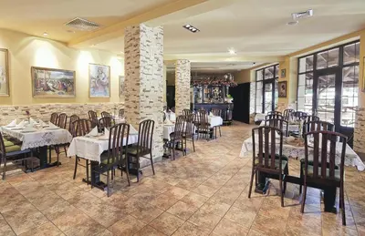 a restaurant with tables and chairs in a room at Hotel TERESITA in Kraków