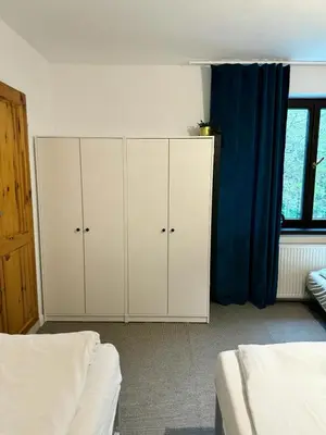 a bedroom with white cabinets and a blue curtain at Villa Vincentów in Myślenice