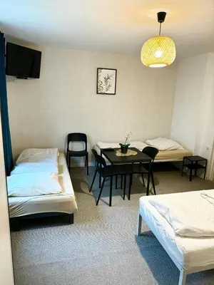 a room with two beds and a table and chairs at Villa Vincentów in Myślenice