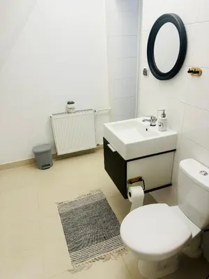 a white bathroom with a toilet and a sink at Villa Vincentów in Myślenice