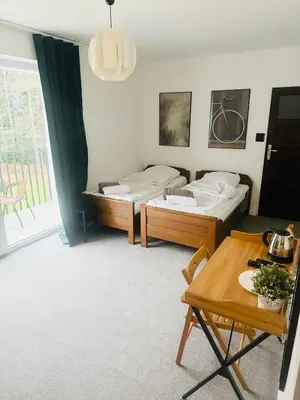 a living room with two beds and a table at Villa Vincentów in Myślenice