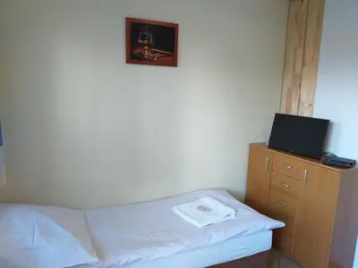 a bedroom with a bed and a tv on a dresser at Zajazd Joniec Małgorzata in Dobra