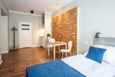 a bedroom with a brick wall and a bed and a table at Flaminio Smart Sleep in Kraków