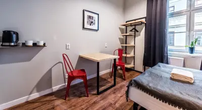 a room with a desk and a bed and a table and chairs at Flaminio Smart Sleep in Kraków