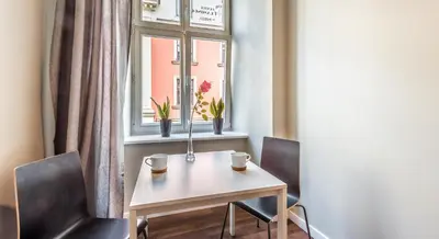 a table and two chairs in a room with a window at Flaminio Smart Sleep in Kraków
