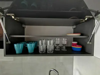 a shelf with glasses on it in a kitchen at Apartament Cyprys 2 in Oświęcim