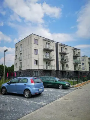 two cars parked in a parking lot in front of a building at Apartament Cyprys 2 in Oświęcim