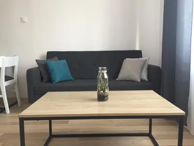 a vase on a table in front of a couch at Apartament loft Krzeszowice centrum in Krzeszowice