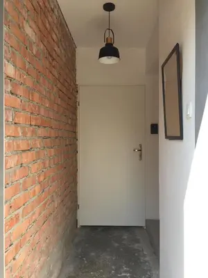 an empty hallway with a brick wall and a white door at Apartament loft Krzeszowice centrum in Krzeszowice