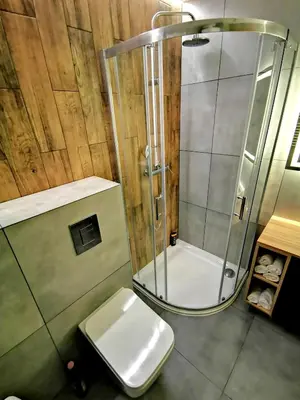 a bathroom with a glass shower and a toilet at Apartment Cyprys 1 in Oświęcim