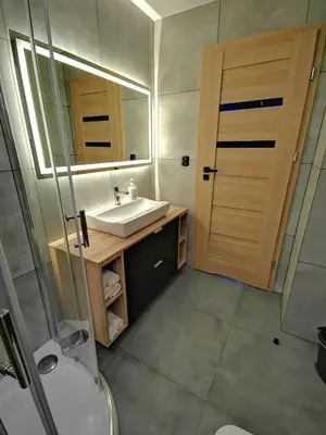 a bathroom with a sink and a mirror at Apartment Cyprys 1 in Oświęcim