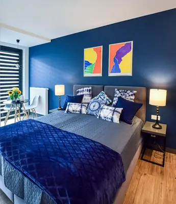 a blue bedroom with a large bed with blue walls at In City Apartments Rajska 3 in Kraków