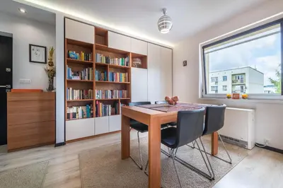 a dining room with a table and chairs and a book shelf at do parku zdrojowego 1 krok in Rabka