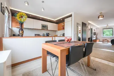 a kitchen and dining room with a wooden table and chairs at do parku zdrojowego 1 krok in Rabka