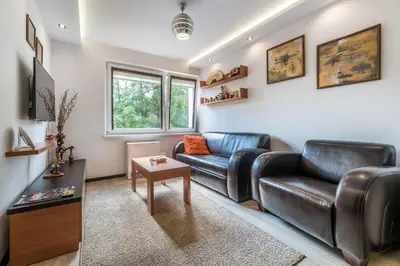 a living room with a leather couch and a table at do parku zdrojowego 1 krok in Rabka