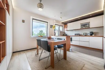 a kitchen with a wooden table and black chairs at do parku zdrojowego 1 krok in Rabka