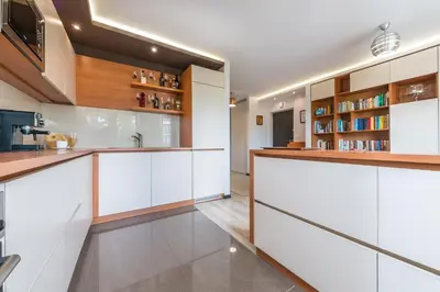 a kitchen with white cabinets and wooden shelves at do parku zdrojowego 1 krok in Rabka