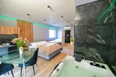 a living room with a bed and a tub and a bedroom at Słoneczne Wzgórze Zator in Zator