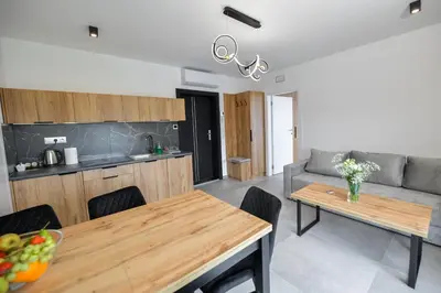 a kitchen and living room with a table and a couch at Słoneczne Wzgórze Zator in Zator