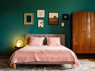 a bedroom with a green wall and a bed with pink pillows at Green view apartment / Kochanowskiego in Kraków