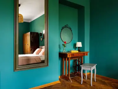 a room with a mirror and a table with a bed at Green view apartment / Kochanowskiego in Kraków