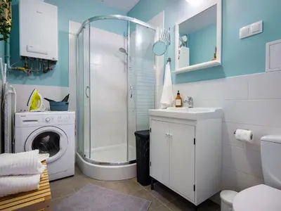 a bathroom with a shower sink and a washing machine at Green view apartment / Kochanowskiego in Kraków