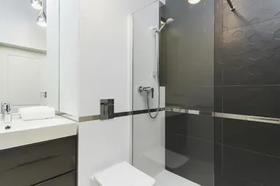 a bathroom with a shower and a toilet and a sink at Apartment Krakow Arianska by Renters Prestige in Kraków