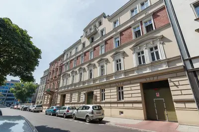 a building with cars parked in front of it on a street at Apartment Krakow Arianska by Renters Prestige in Kraków