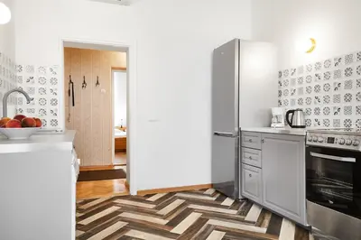 a kitchen with stainless steel appliances and a geometric floor at Top Location Apartments Topolowa Street in Kraków