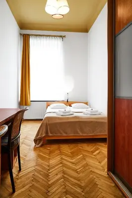 a bedroom with a bed and a desk and a window at Top Location Apartments Topolowa Street in Kraków