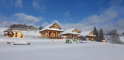 a group of wooden buildings in the snow at Domki Gorce Klikuszowa Sauna Jacuzzi in Klikuszowa