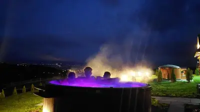 a group of people sitting in a fountain at night at Domki Gorce Klikuszowa Sauna Jacuzzi in Klikuszowa