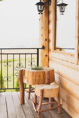 a wooden table and bench on a porch with a window at Domki Gorce Klikuszowa Sauna Jacuzzi in Klikuszowa