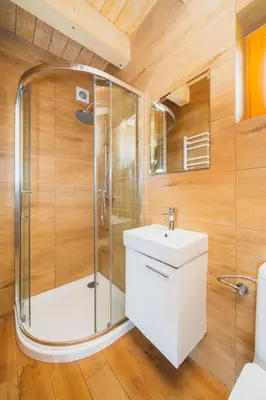 a bathroom with a shower and a sink at Domki Gorce Klikuszowa Sauna Jacuzzi in Klikuszowa
