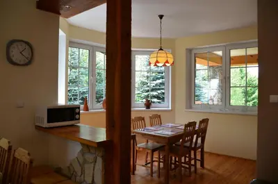 a kitchen and dining room with a table and a microwave at Dom w Beskidach in Stryszawa