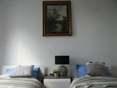 a bedroom with two beds and a picture on the wall at Beautiful City Centre Apartament in Kraków