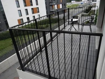 a balcony with a black railing and a table at Beautiful City Centre Apartament in Kraków