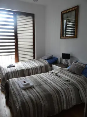 a bedroom with two beds and a mirror on the wall at Beautiful City Centre Apartament in Kraków
