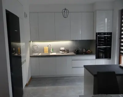 a kitchen with white cabinets and a black counter top at Beautiful City Centre Apartament in Kraków