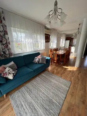 a living room with a blue couch and a dining room at Dom nad Skawą - Zator 5km in Grodzisko