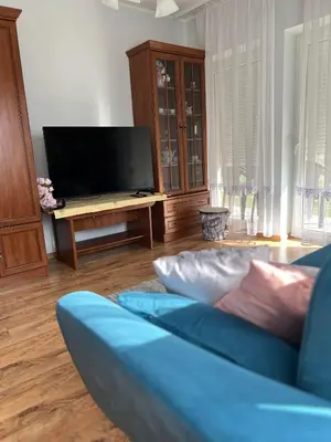 a living room with a blue couch and a tv at Dom nad Skawą - Zator 5km in Grodzisko