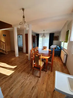 a dining room and living room with a table and chairs at Dom nad Skawą - Zator 5km in Grodzisko