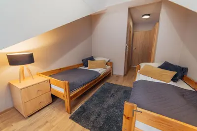 a bedroom with two twin beds and a lamp at Gościniec pod Lilijką in Podzamcze